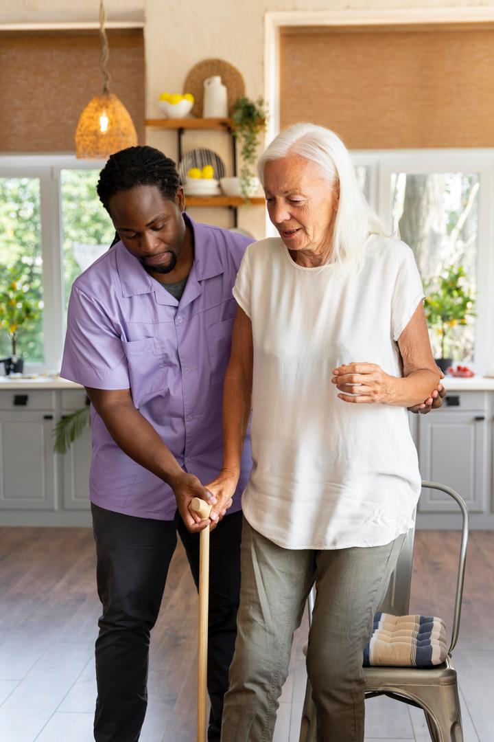 Caregivers interacting warmly helping out an elderly woman holding a support